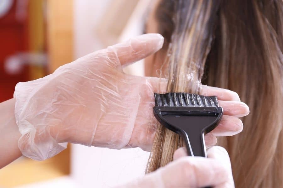 woman with long hair having her hair dyed 